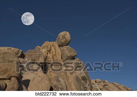 Stock Image - "Full moon above rock formation, Mojave Desert, California, United States, ". Fotosearch