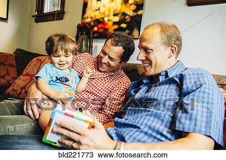 Gay fathers playing with baby son on sofa View Large Photo Image Stock Image - Gay fathers playing with baby son on sofa. Fotosearch