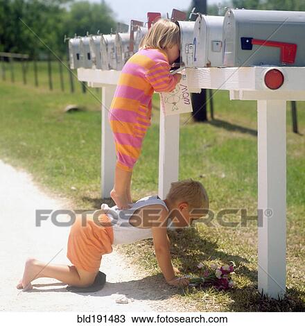 Stock Image - Girl standing on brother's back and peering into mailbox. Fotosearch