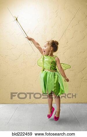 Stock Photo - Girl wearing green fairy costume with wand. Fotosearch
