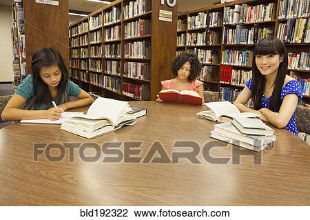 Girls doing homework in library View Large Photo Image Stock Image - Girls doing homework in library. Fotosearch