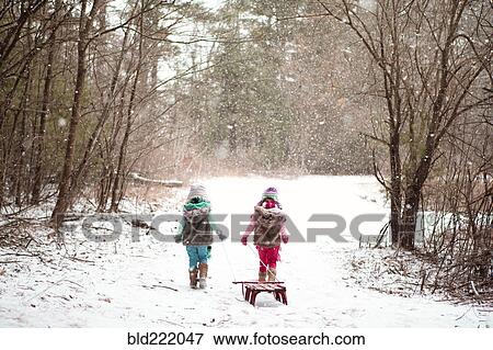 Stock Photo - Girls walking in snowy field. Fotosearch