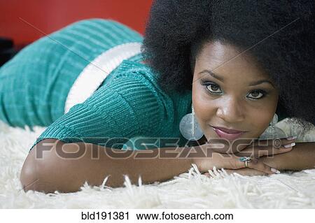 Stock Image - Glamorous mixed race woman laying on floor. Fotosearch