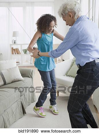 Grandmother and granddaughter dancing in living room View Large Photo Image Stock Image - Grandmother and granddaughter dancing in living room. Fotosearch