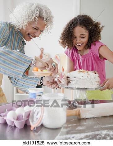 Grandmother and granddaughter frosting cake View Large Photo Image Stock Photo - Grandmother and granddaughter frosting cake. Fotosearch