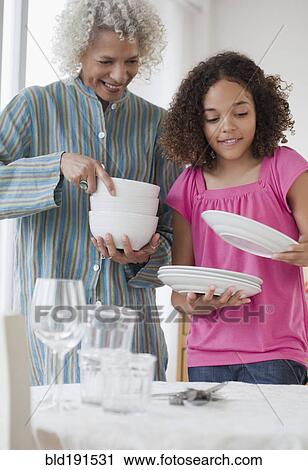 Grandmother and granddaughter setting table View Large Photo Image Stock Image - Grandmother and granddaughter setting table. Fotosearch