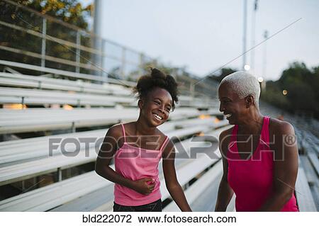 Grandmother and granddaughter standing on bleachers View Large Photo Image Stock Image - Grandmother and granddaughter standing on bleachers. Fotosearch