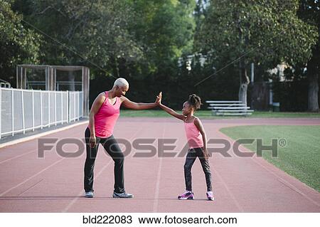Grandmother and granddaughter high-fiving on track View Large Photo Image Stock Image - Grandmother and granddaughter high-fiving on track. Fotosearch