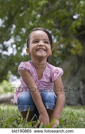 Grinning Hispanic preschool girl squatting in grass View Large Photo Image Stock Photography - Grinning Hispanic preschool girl squatting in grass. Fotosearch