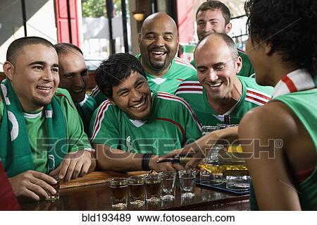 Happy men drinking shots in sports bar View Large Photo Image Stock Photo - Happy men drinking shots in sports bar. Fotosearch