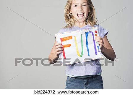 Happy Mixed Race girl holding fun sign View Large Photo Image Stock Image - Happy Mixed Race girl holding fun sign. Fotosearch