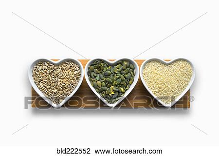 Stock Image - Heart-shaped bowls of heart-healthy seeds. Fotosearch