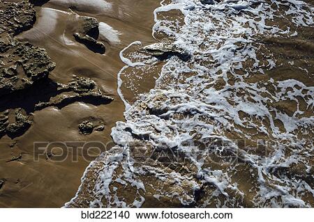 Stock Image - High angle view of waves on beach. Fotosearch