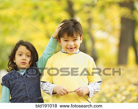 Stock Photo - Hispanic brother and sister outdoors in autumn. Fotosearch