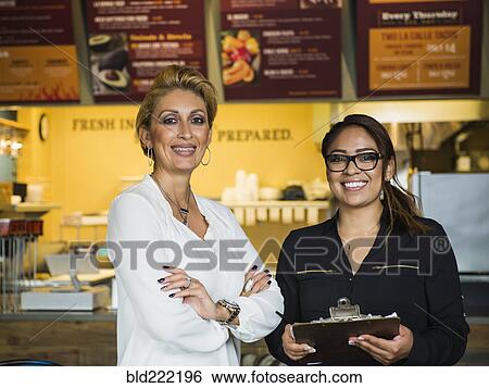Hispanic business owner and employee smiling in cafe View Large Photo Image Stock Photograph - Hispanic business owner and employee smiling in cafe. Fotosearch
