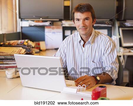 Hispanic businessman sitting at desk View Large Photo Image Stock Image - Hispanic businessman sitting at desk. Fotosearch