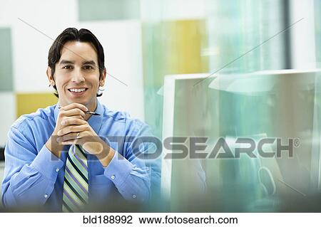Stock Image - Hispanic businessman working in office. Fotosearch