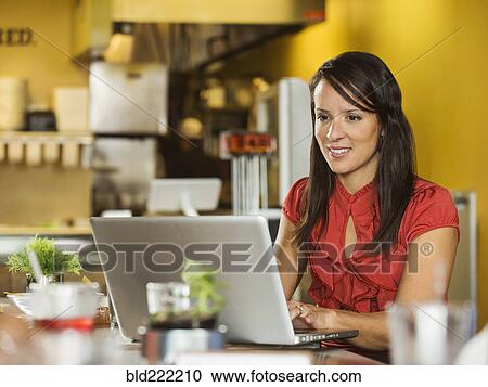 Hispanic businesswoman using laptop in cafe View Large Photo Image Stock Image - Hispanic businesswoman using laptop in cafe. Fotosearch