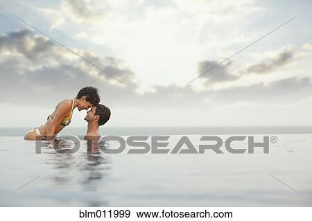 Stock Photo - Hispanic couple enjoying swimming pool. Fotosearch
