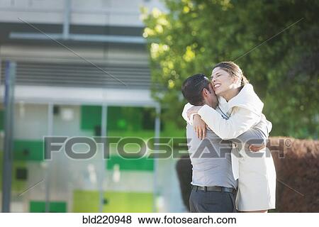 Stock Photo - Hispanic couple hugging in city. Fotosearch