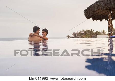 Hispanic couple hugging in swimming pool View Large Photo Image Stock Image - Hispanic couple hugging in swimming pool. Fotosearch