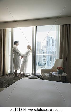 Hispanic couple in bathrobes holding hands by window View Large Photo Image Stock Photograph - Hispanic couple in bathrobes holding hands by window. Fotosearch