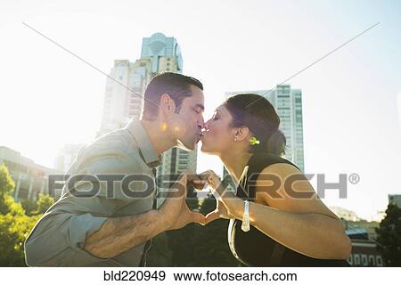 Hispanic couple kissing and making heart shape View Large Photo Image Stock Photo - Hispanic couple kissing and making heart shape. Fotosearch