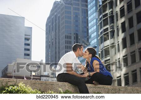 Stock Photography - Hispanic couple kissing in city. Fotosearch
