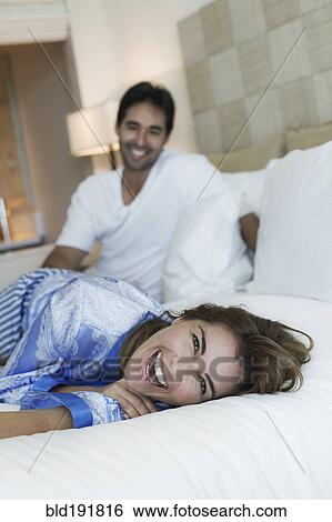 Stock Photograph - Hispanic couple laying on bed. Fotosearch