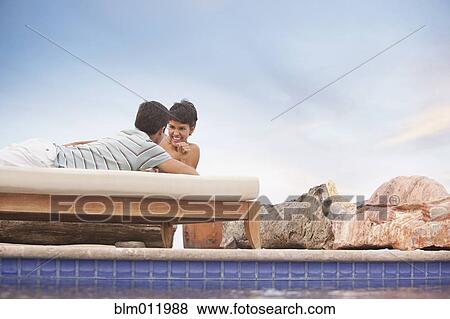 Hispanic couple relaxing at poolside View Large Photo Image Stock Photo - Hispanic couple relaxing at poolside. Fotosearch