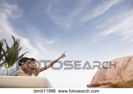 Stock Photograph - Hispanic couple relaxing outdoors. Fotosearch