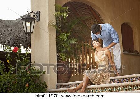 Stock Photo - Hispanic couple sitting on front stoop. Fotosearch