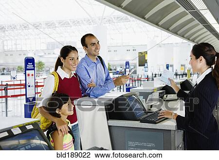Stock Image - Hispanic family checking in at airport. Fotosearch