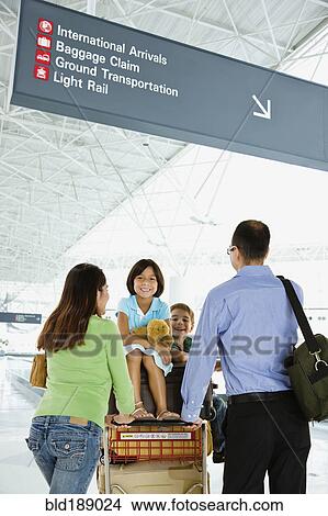 Hispanic family with luggage cart in airport View Large Photo Image Picture - Hispanic family with luggage cart in airport. Fotosearch