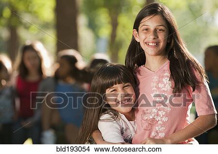 Picture - Hispanic girls hugging. Fotosearch