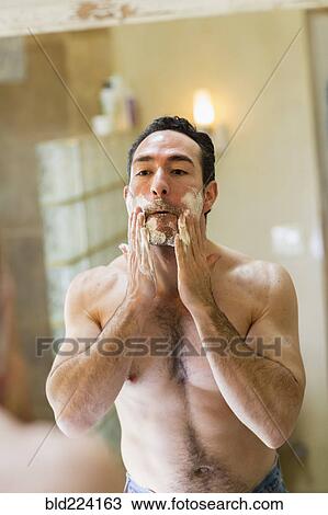 Hispanic man applying shaving cream to face in mirror View Large Photo Image Stock Image - Hispanic man applying shaving cream to face in mirror. Fotosearch
