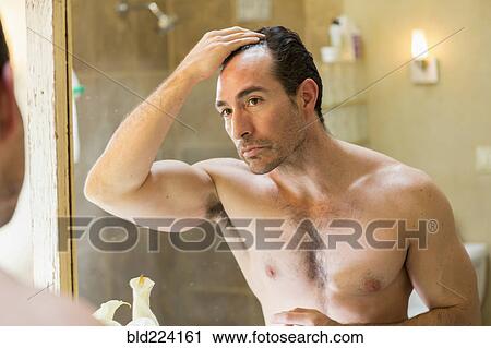 Hispanic man checking receding hairline in mirror View Large Photo Image Stock Image - Hispanic man checking receding hairline in mirror. Fotosearch
