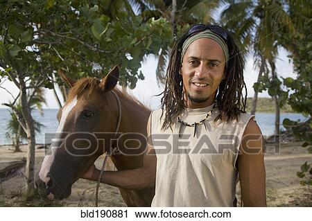 Hispanic man leading horse near beach View Large Photo Image Stock Image - Hispanic man leading horse near beach. Fotosearch