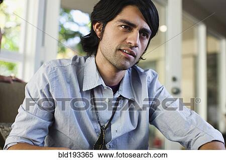 Hispanic man sitting indoors View Large Photo Image Stock Photography - Hispanic man sitting indoors. Fotosearch