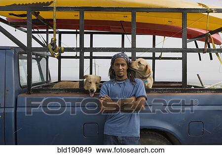 Hispanic man with dogs leaning against truck View Large Photo Image Stock Photo - Hispanic man with dogs leaning against truck. Fotosearch