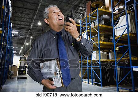 Stock Photo - Hispanic man working in warehouse. Fotosearch