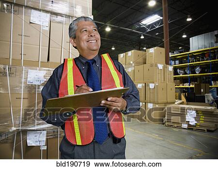 Stock Photo - Hispanic man working in warehouse. Fotosearch