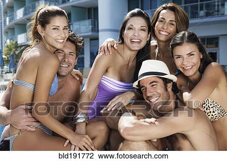 Stock Image - Hispanic men and women poolside. Fotosearch