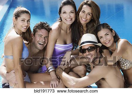 Stock Image - Hispanic men and women poolside. Fotosearch