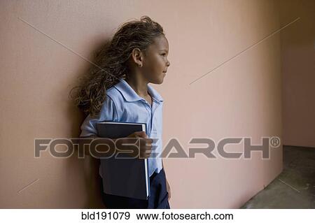 Stock Photo - Hispanic school girl holding textbook. Fotosearch