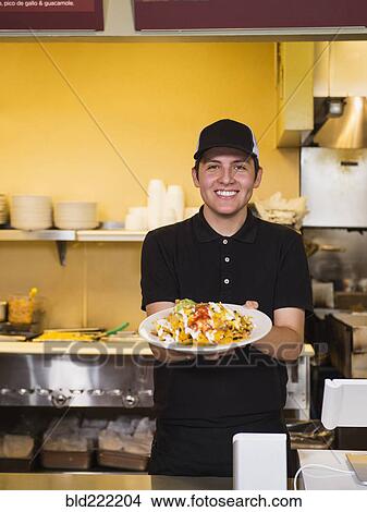 Picture - Hispanic server holding food in cafe. Fotosearch