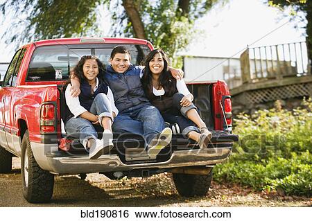 Hispanic siblings sitting in bed of truck View Large Photo Image Stock Photograph - Hispanic siblings sitting in bed of truck. Fotosearch