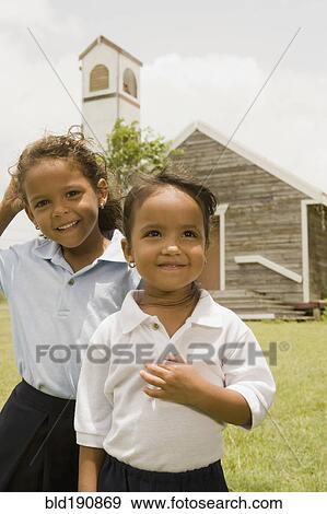 Stock Photo - Hispanic sisters standing outside church. Fotosearch