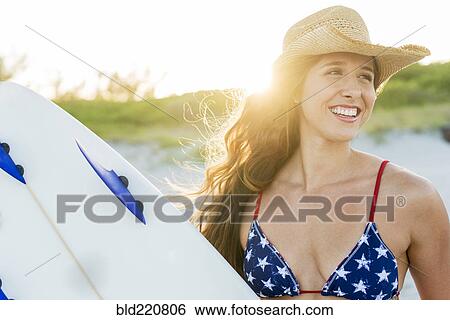 Hispanic woman carrying surfboard on beach View Large Photo Image Stock Photograph - Hispanic woman carrying surfboard on beach. Fotosearch