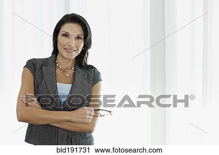 Stock Image - Hispanic woman holding eyeglasses. Fotosearch
